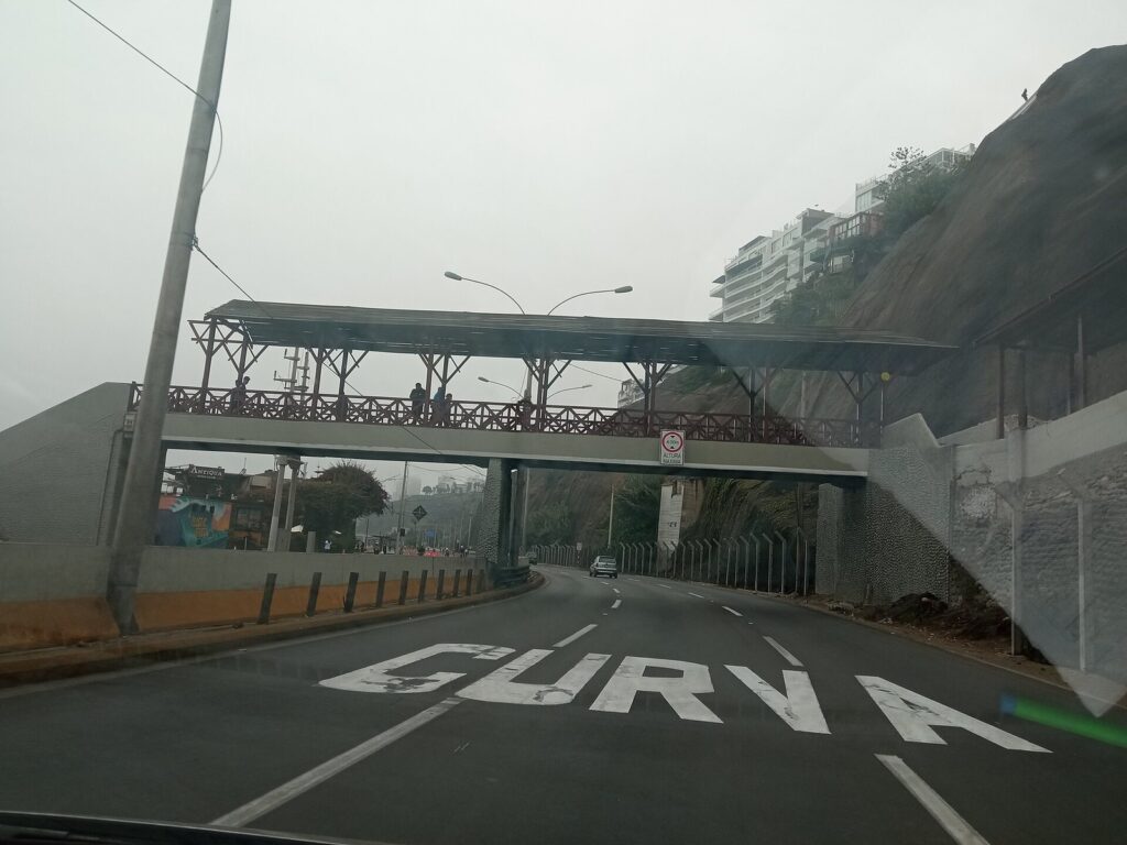 Footbridge over the Costa Verde road at the foot of the Bajada de los Baños in Barranco, Lima, under a gray sky