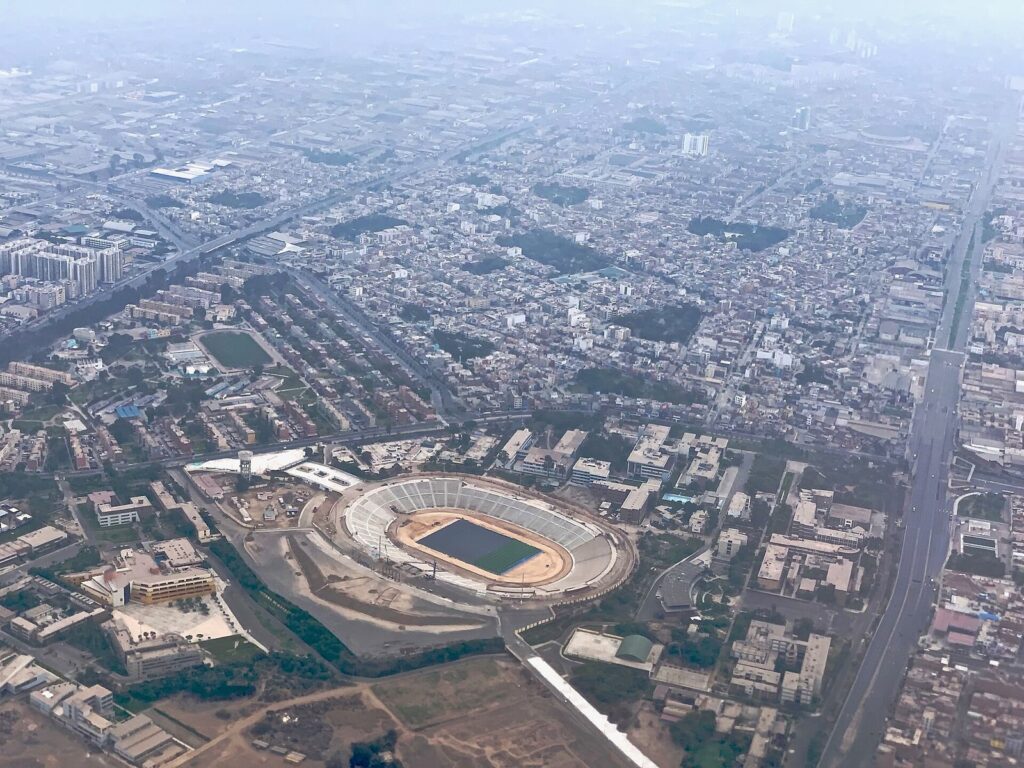 Aerial view of Lima's dense neighborhoods and a large stadium seen from an aircraft on a hazy morning