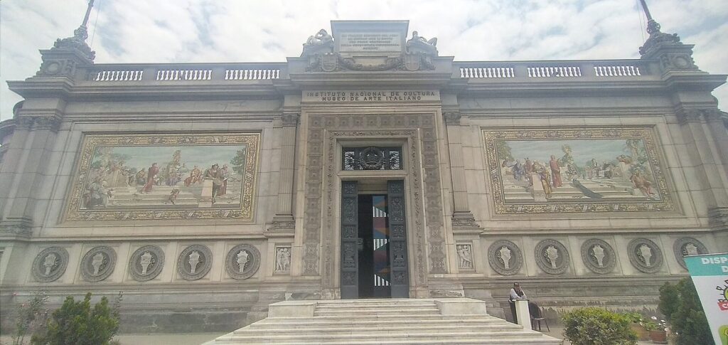 Stone facade of the Museo de Arte Italiano on Paseo de la República in Lima with mosaic panels on either side of the entrance