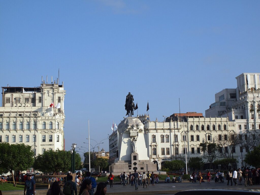 Equestrian statue of José de San Martín on the Plaza San Martín in Lima's historic center, framed by ornate white buildings under a blue sky